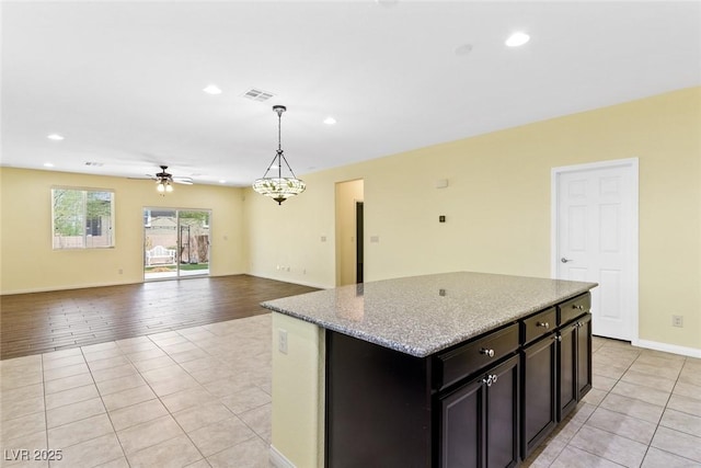 3012 Chiefs Ct, North Las Vegas, NV 89032 - kitchen featuring light tile patterned floors, ceiling fan, a kitchen island, hanging light fixtures, and recessed lighting