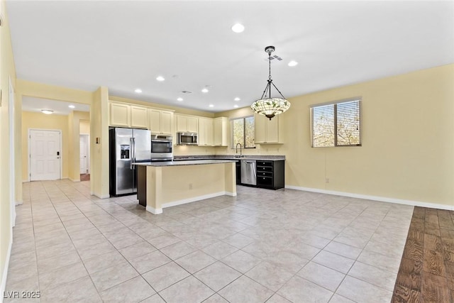 3012 Chiefs Ct, North Las Vegas, NV 89032 - kitchen featuring appliances with stainless steel finishes, a center island, open floor plan, cream cabinets, and recessed lighting