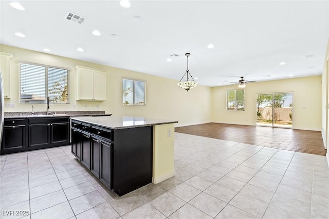 3012 Chiefs Ct, North Las Vegas, NV 89032 - kitchen featuring dark cabinets, light tile patterned floors, recessed lighting, open floor plan, and a ceiling fan