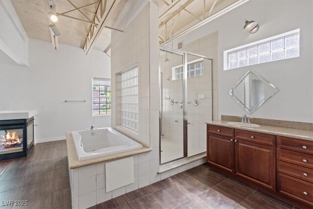 5603 Deer Creek Falls Ct, Las Vegas, NV 89118 - full bathroom featuring vanity, a bath, a shower stall, a multi sided fireplace, and lofted ceiling