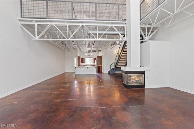 5603 Deer Creek Falls Ct, Las Vegas, NV 89118 - unfurnished living room with concrete flooring and stairway