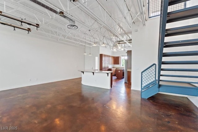 5603 Deer Creek Falls Ct, Las Vegas, NV 89118 - unfurnished living room featuring concrete flooring and stairway