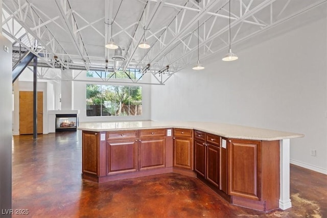 5603 Deer Creek Falls Ct, Las Vegas, NV 89118 - kitchen with concrete floors, a lit fireplace, decorative light fixtures, open floor plan, and brown cabinets