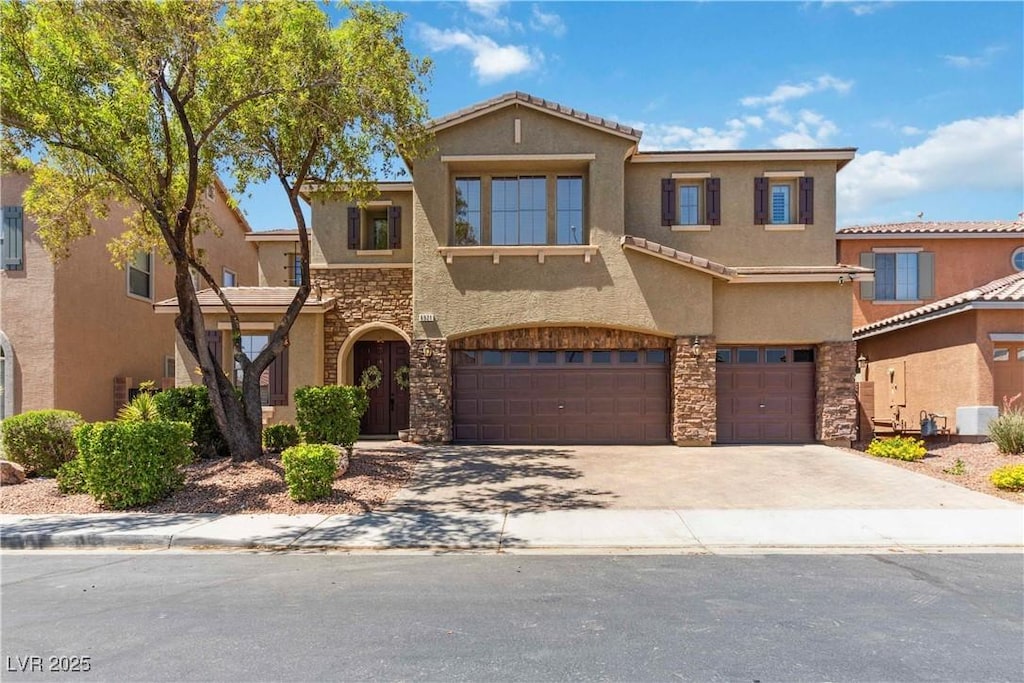 6921 Puetollano Dr, North Las Vegas, NV 89084 - view of front of home with stone siding, a garage, stucco siding, and driveway