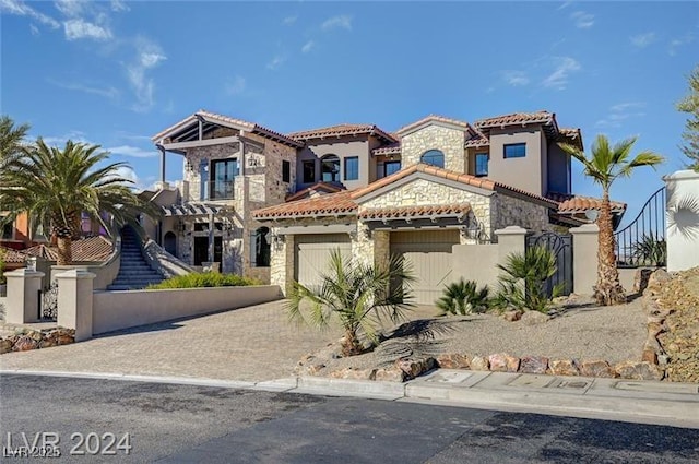 30 Via Tiberius Way, Henderson, NV 89011 - mediterranean / spanish house featuring stone siding, a tile roof, driveway, stucco siding, and a gate