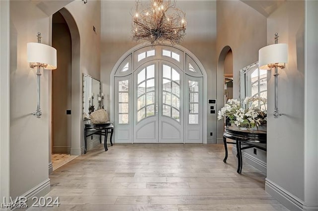 30 Via Tiberius Way, Henderson, NV 89011 - entryway with arched walkways, a high ceiling, a chandelier, wood finished floors, and healthy amount of natural light