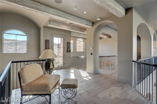 30 Via Tiberius Way, Henderson, NV 89011 - sitting room featuring beam ceiling, an upstairs landing, healthy amount of natural light, and arched walkways