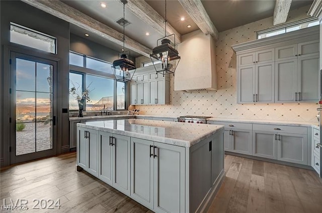 30 Via Tiberius Way, Henderson, NV 89011 - kitchen featuring beamed ceiling, hardwood / wood-style flooring, gray cabinetry, a center island, and light stone countertops