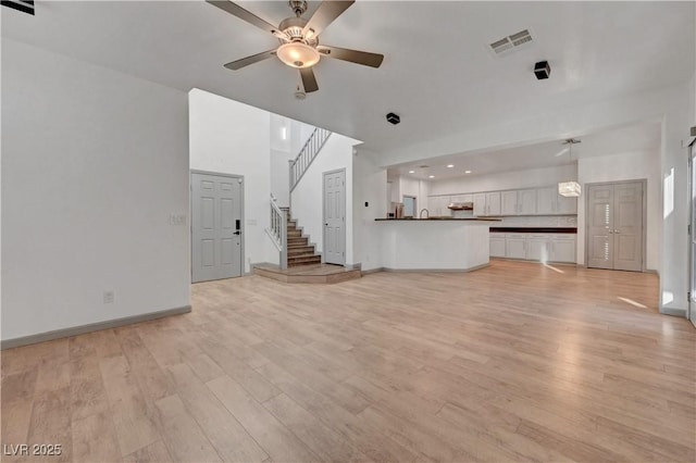 1069 Aspen Cliff Dr, Henderson, NV 89011 - unfurnished living room with stairway, a ceiling fan, and light wood-style flooring