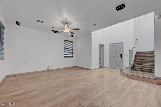 1069 Aspen Cliff Dr, Henderson, NV 89011 - unfurnished living room with ceiling fan, light wood-style flooring, and stairs