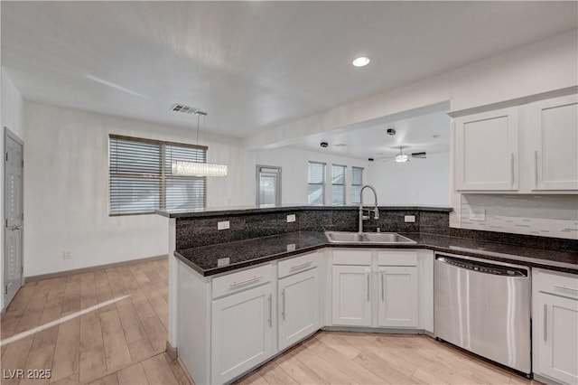 1069 Aspen Cliff Dr, Henderson, NV 89011 - kitchen featuring dishwasher, a peninsula, light wood-type flooring, dark stone countertops, and a ceiling fan