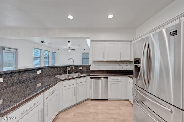 1069 Aspen Cliff Dr, Henderson, NV 89011 - kitchen featuring appliances with stainless steel finishes, backsplash, dark stone counters, white cabinetry, and ceiling fan