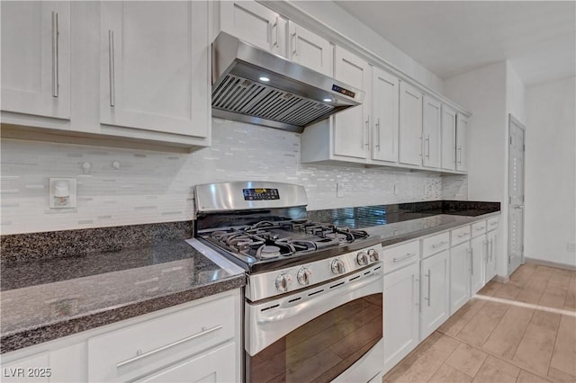 1069 Aspen Cliff Dr, Henderson, NV 89011 - kitchen featuring stainless steel gas range, under cabinet range hood, white cabinetry, and dark stone countertops