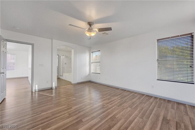 1069 Aspen Cliff Dr, Henderson, NV 89011 - empty room with arched walkways, ceiling fan, and wood finished floors