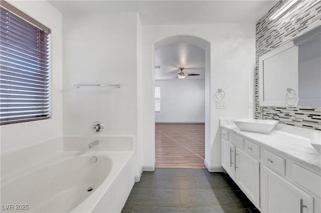 1069 Aspen Cliff Dr, Henderson, NV 89011 - full bath featuring ceiling fan, a garden tub, vanity, tasteful backsplash, and tile patterned flooring