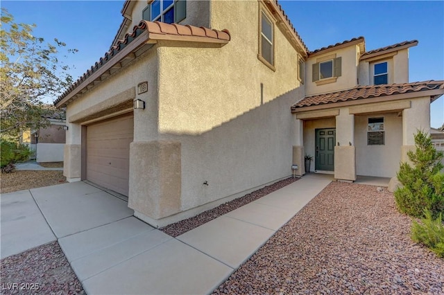 1069 Aspen Cliff Dr, Henderson, NV 89011 - view of front of home with a tile roof, stucco siding, concrete driveway, and a garage