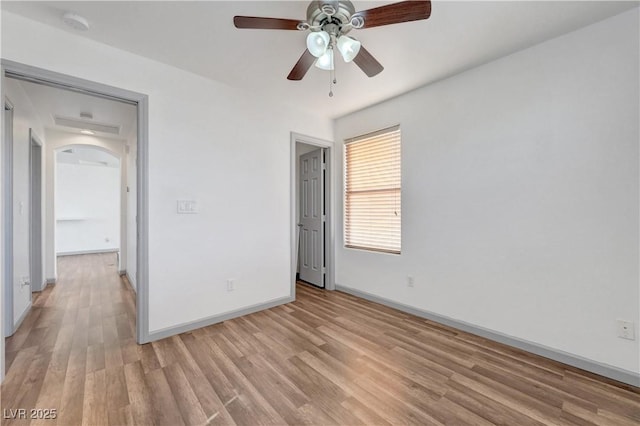 1069 Aspen Cliff Dr, Henderson, NV 89011 - unfurnished bedroom featuring light wood-style flooring, ceiling fan, and arched walkways
