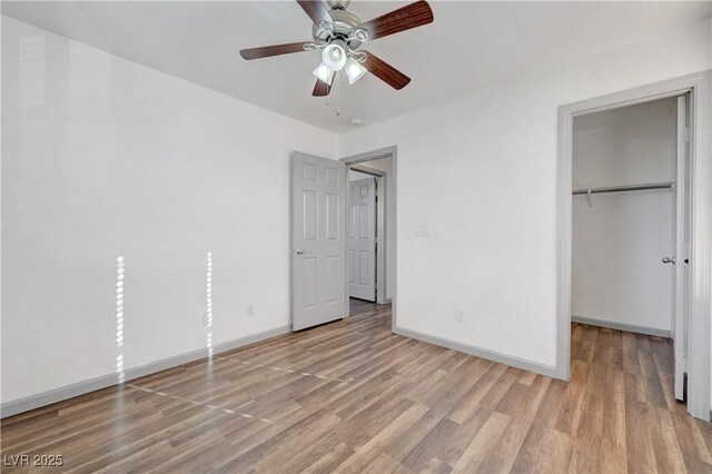 1069 Aspen Cliff Dr, Henderson, NV 89011 - unfurnished bedroom with light wood-type flooring, a closet, a spacious closet, and ceiling fan