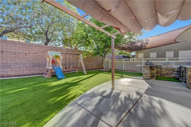 1069 Aspen Cliff Dr, Henderson, NV 89011 - fenced backyard featuring a playground, area for grilling, and a patio area