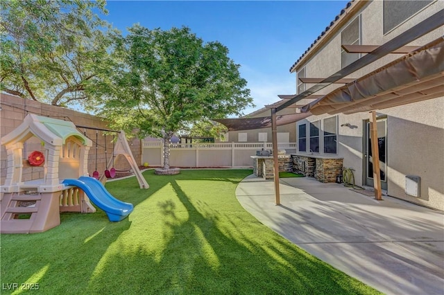 1069 Aspen Cliff Dr, Henderson, NV 89011 - fenced backyard featuring a patio area and a playground