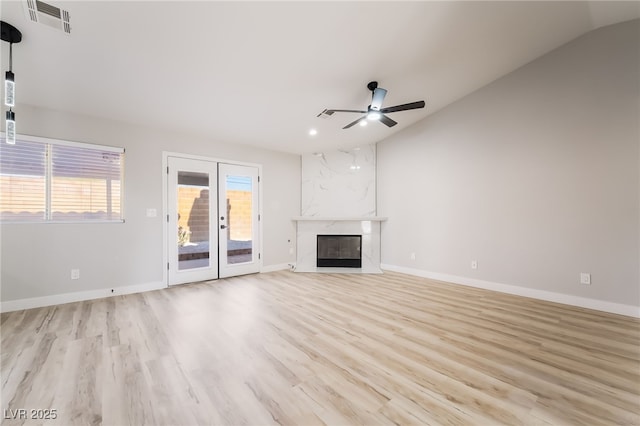 5417 Bible Cir, North Las Vegas, NV 89031 - unfurnished living room with vaulted ceiling, ceiling fan, light wood-type flooring, french doors, and a premium fireplace