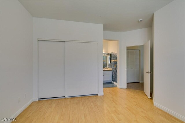10513 Shanna Trellis Ave, Las Vegas, NV 89144 - unfurnished bedroom featuring light wood finished floors, a closet, and ensuite bath