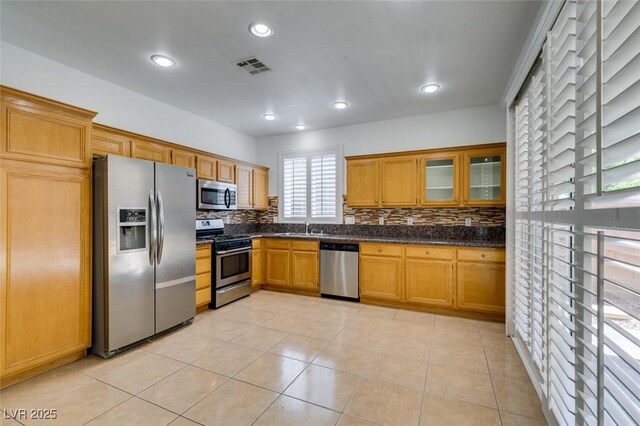 10513 Shanna Trellis Ave, Las Vegas, NV 89144 - kitchen featuring appliances with stainless steel finishes, decorative backsplash, glass insert cabinets, recessed lighting, and light tile patterned floors