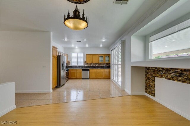 10513 Shanna Trellis Ave, Las Vegas, NV 89144 - kitchen with appliances with stainless steel finishes, dark countertops, light tile patterned floors, tasteful backsplash, and recessed lighting