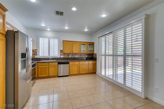 10513 Shanna Trellis Ave, Las Vegas, NV 89144 - kitchen featuring appliances with stainless steel finishes, healthy amount of natural light, light tile patterned flooring, glass insert cabinets, and recessed lighting