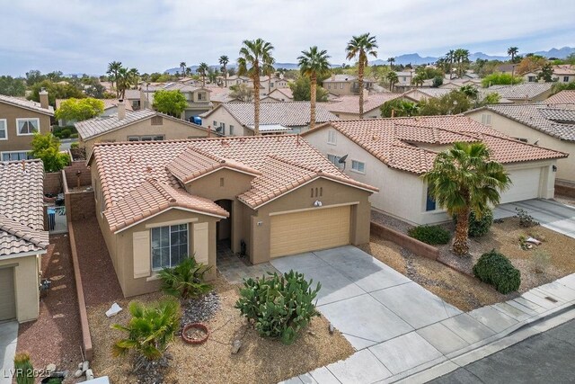 10513 Shanna Trellis Ave, Las Vegas, NV 89144 - mediterranean / spanish house featuring a residential view, an attached garage, stucco siding, concrete driveway, and a tile roof