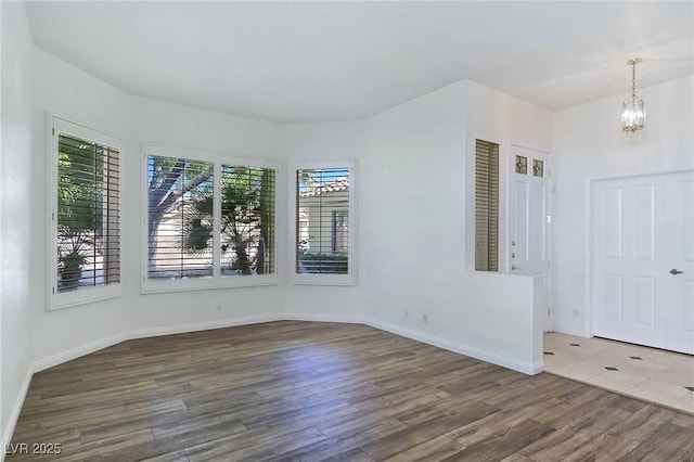 8981 Rivers Edge Dr, Las Vegas, NV 89117 - spare room with healthy amount of natural light, wood finished floors, and a chandelier