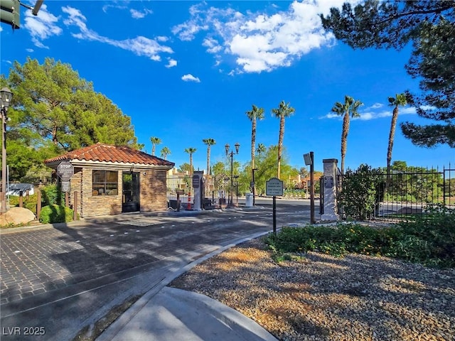 8981 Rivers Edge Dr, Las Vegas, NV 89117 - view of asphalt street with street lights, curbs, and a gated entry