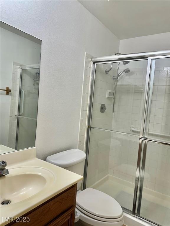 5576 W Rochelle Ave Unit 27A, Las Vegas, NV 89103 - full bathroom featuring vanity, a shower stall, and a textured wall