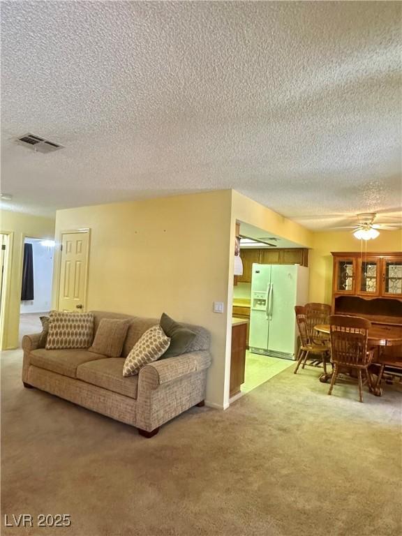 5576 W Rochelle Ave Unit 27A, Las Vegas, NV 89103 - living area with a textured ceiling, light colored carpet, and a ceiling fan
