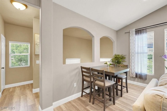 9975 Peace Way Unit 2009, Las Vegas, NV 89147 - dining space featuring wood finished floors, plenty of natural light, lofted ceiling, and arched walkways