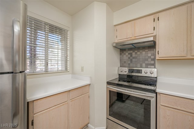 2068 Mesquite Ln Unit 203, Laughlin, NV 89029 - kitchen with appliances with stainless steel finishes, under cabinet range hood, light brown cabinets, light countertops, and decorative backsplash