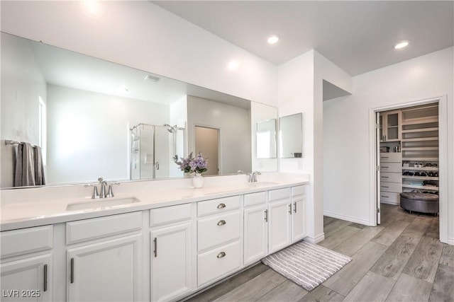 3821 Nesting Wren Dr, North Las Vegas, NV 89084 - full bathroom featuring double vanity, a stall shower, a walk in closet, and wood finished floors