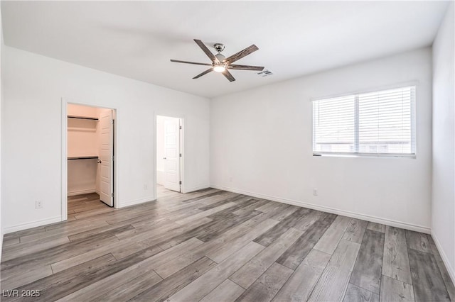 3821 Nesting Wren Dr, North Las Vegas, NV 89084 - unfurnished bedroom with wood finished floors, a spacious closet, a closet, a ceiling fan, and ensuite bath