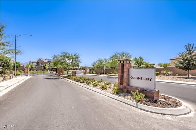3821 Nesting Wren Dr, North Las Vegas, NV 89084 - view of asphalt road with street lighting, curbs, a gated entry, a residential view, and sidewalks