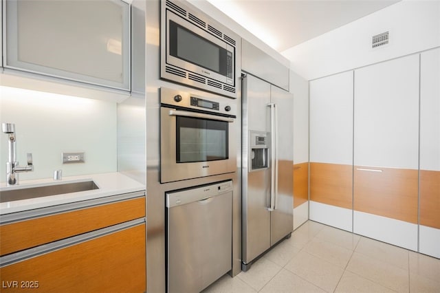 3726 Las Vegas Blvd Unit 704, Las Vegas, NV 89158 - kitchen featuring appliances with stainless steel finishes, light countertops, light tile patterned flooring, white cabinetry, and modern cabinets
