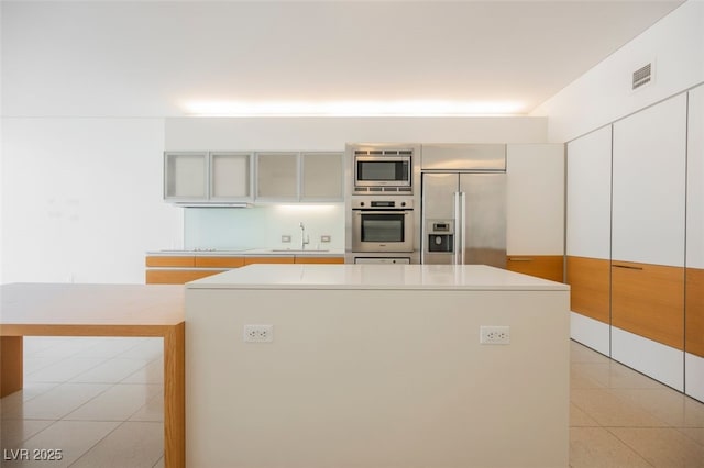 3726 Las Vegas Blvd Unit 704, Las Vegas, NV 89158 - kitchen featuring built in appliances, a center island, light countertops, and light tile patterned floors