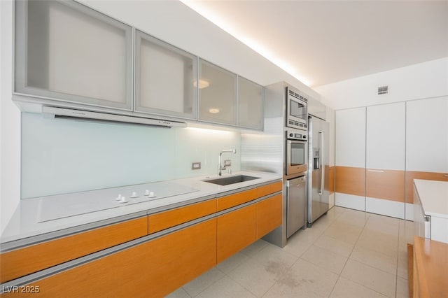 3726 Las Vegas Blvd Unit 704, Las Vegas, NV 89158 - kitchen with appliances with stainless steel finishes, light countertops, glass insert cabinets, light tile patterned flooring, and range hood