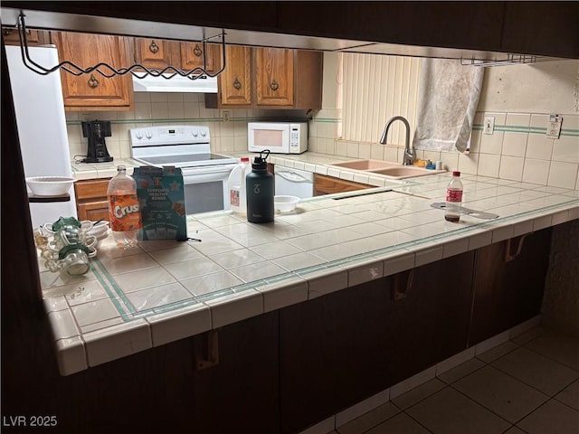4928 E Philadelphia Ave, Las Vegas, NV 89104 - kitchen with white appliances, brown cabinets, and decorative backsplash