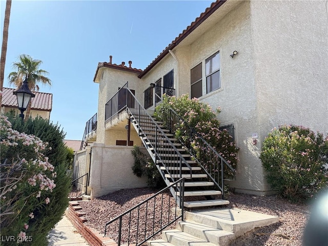 3606 Di Salvo Dr Unit 133, Las Vegas, NV 89103 - view of property exterior featuring stucco siding, stairs, and a tile roof