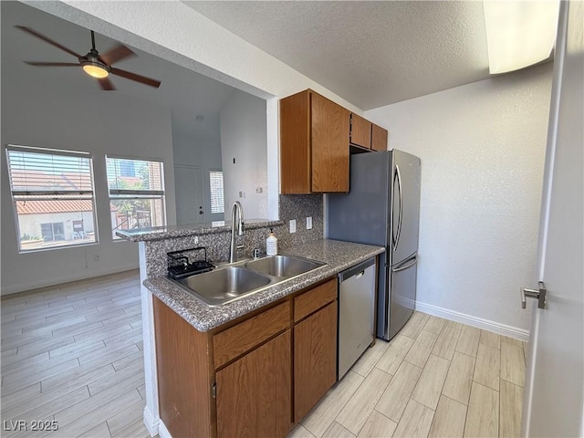 3606 Di Salvo Dr Unit 133, Las Vegas, NV 89103 - kitchen with stainless steel appliances, wood tiled floors, brown cabinetry, ceiling fan, and a textured ceiling
