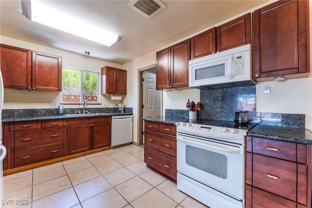 704 N Wallace Dr, Las Vegas, NV 89107 - kitchen featuring white appliances, light tile patterned floors, dark stone counters, and decorative backsplash