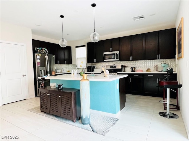 6230 Bravestar Ct, Las Vegas, NV 89141 - kitchen featuring appliances with stainless steel finishes, tasteful backsplash, light countertops, and light tile patterned flooring