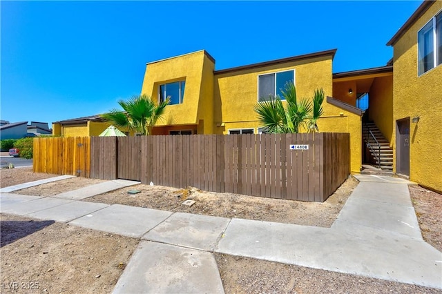 1480 Hialeah Dr Unit B, Las Vegas, NV 89119 - view of property with stairs, a fenced front yard, and stucco siding