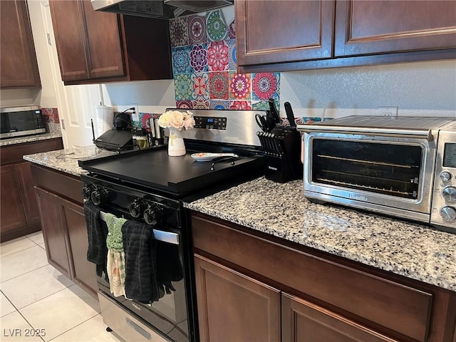 4056 Campeche Ave, Las Vegas, NV 89121 - kitchen featuring electric stove, stainless steel microwave, exhaust hood, dark brown cabinets, and light stone countertops
