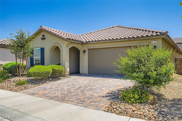 7224 Piute Mesa St, North Las Vegas, NV 89084 - mediterranean / spanish home featuring an attached garage, stucco siding, decorative driveway, and a tiled roof